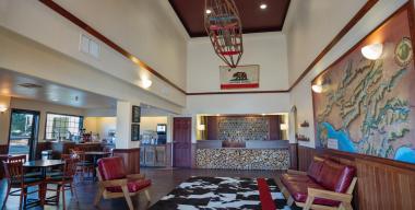 link to full image of The Redwood Riverwalk Hotel lobby, front desk, and dining area